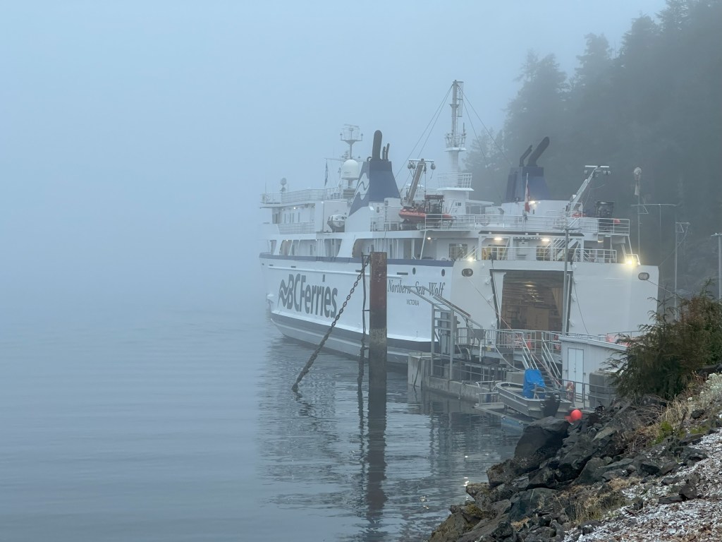 A BC ferry docked in a foggy cove.
